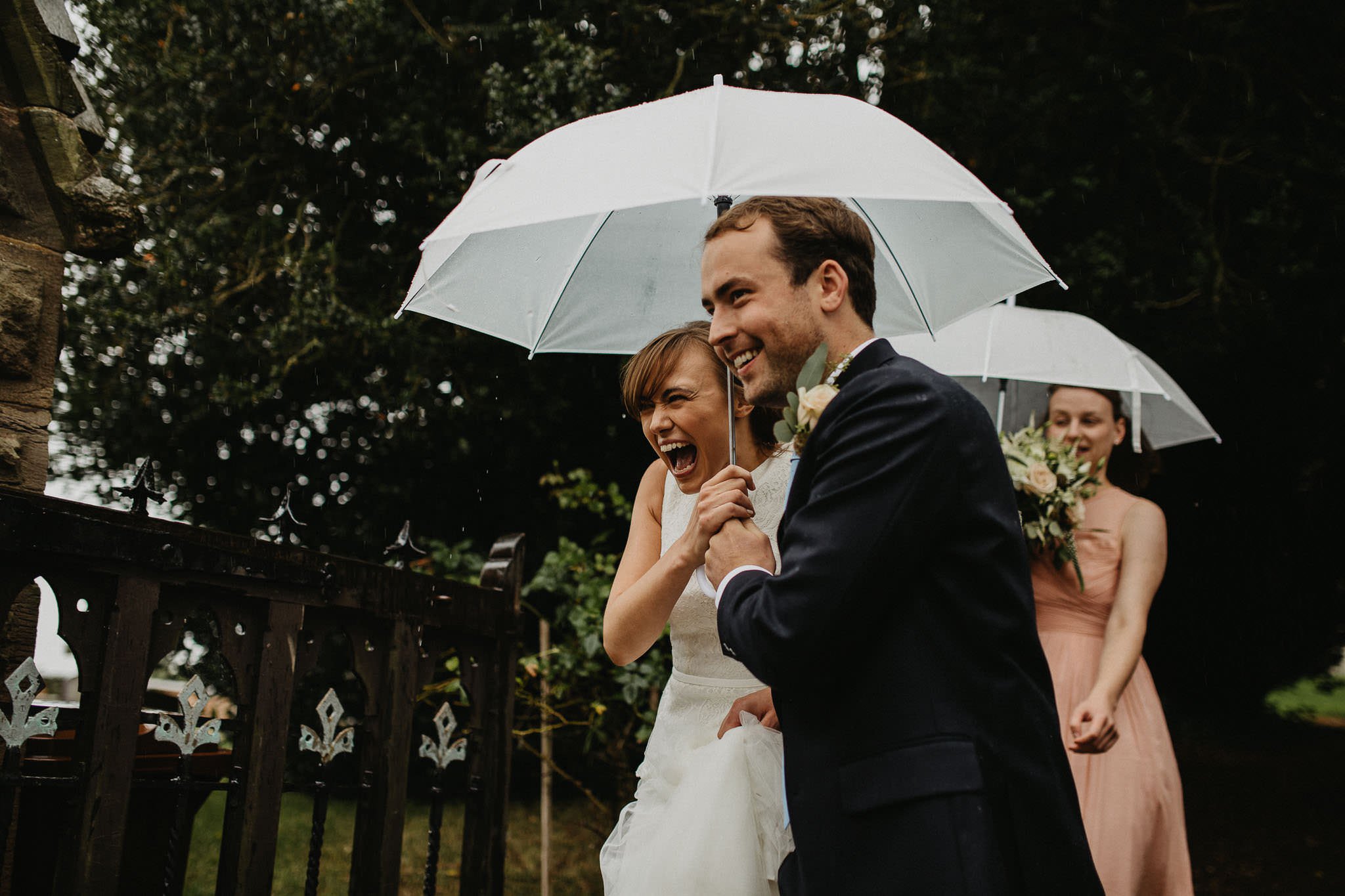 bride and groom walking down in the rain